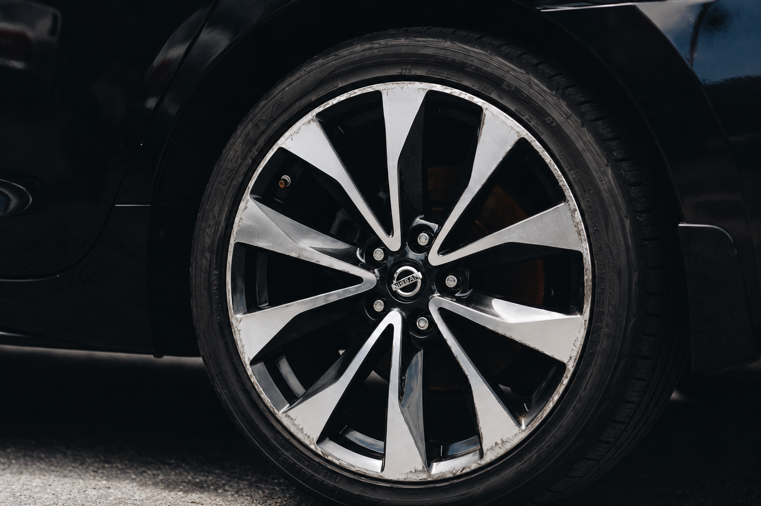 Nissan alloy wheel kerb damage before ScuffIQ repair